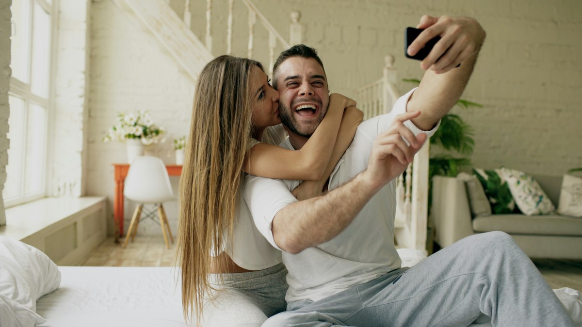 A couple taking a selfie in a bright, modern room