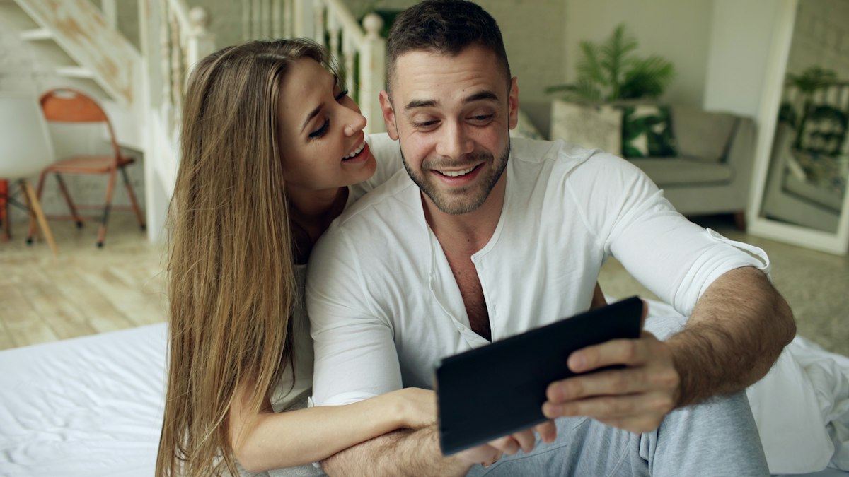 A couple looking at a tablet together with smiles